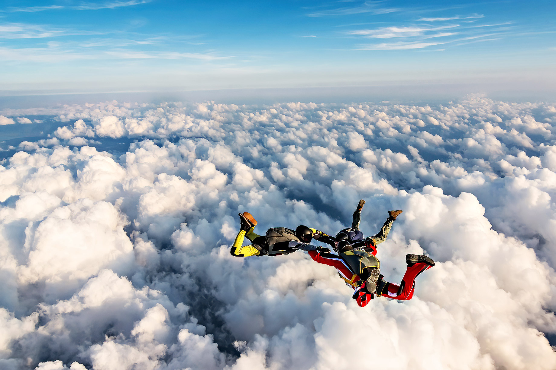 Group Of Skydivers Above The Clouds