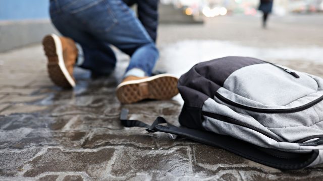 Man with Backpack Falling on Slippery Sidewalk