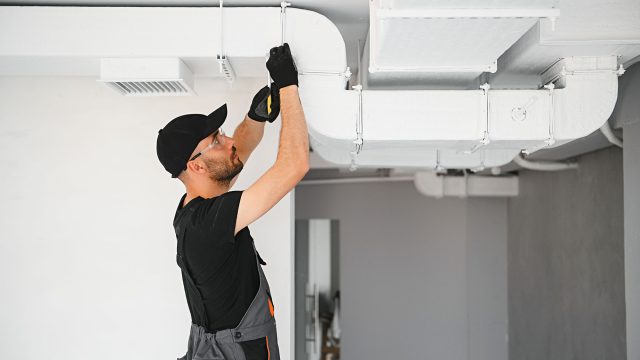 Professional HVAC Technician Working on Air Ducts