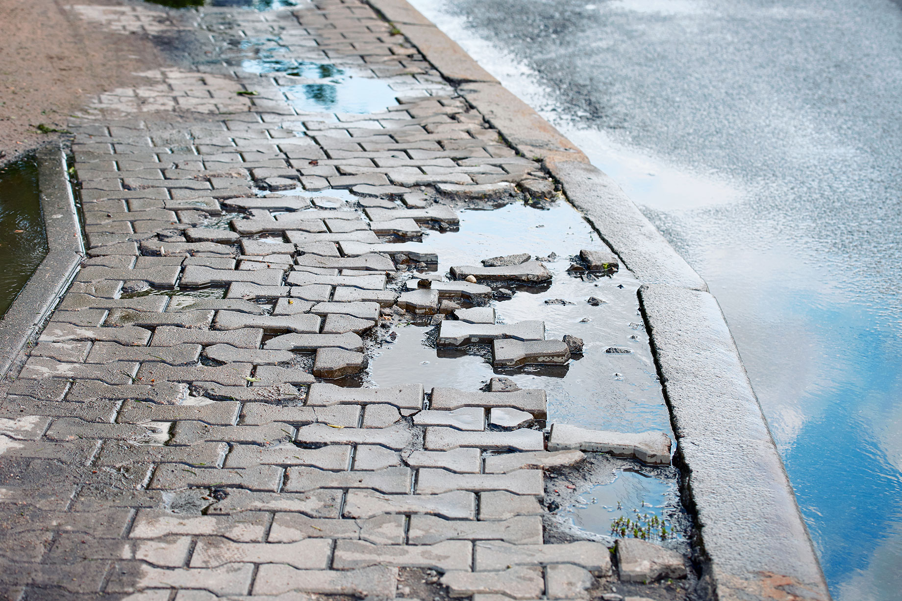 Broken Sidewalk with Puddles of Water