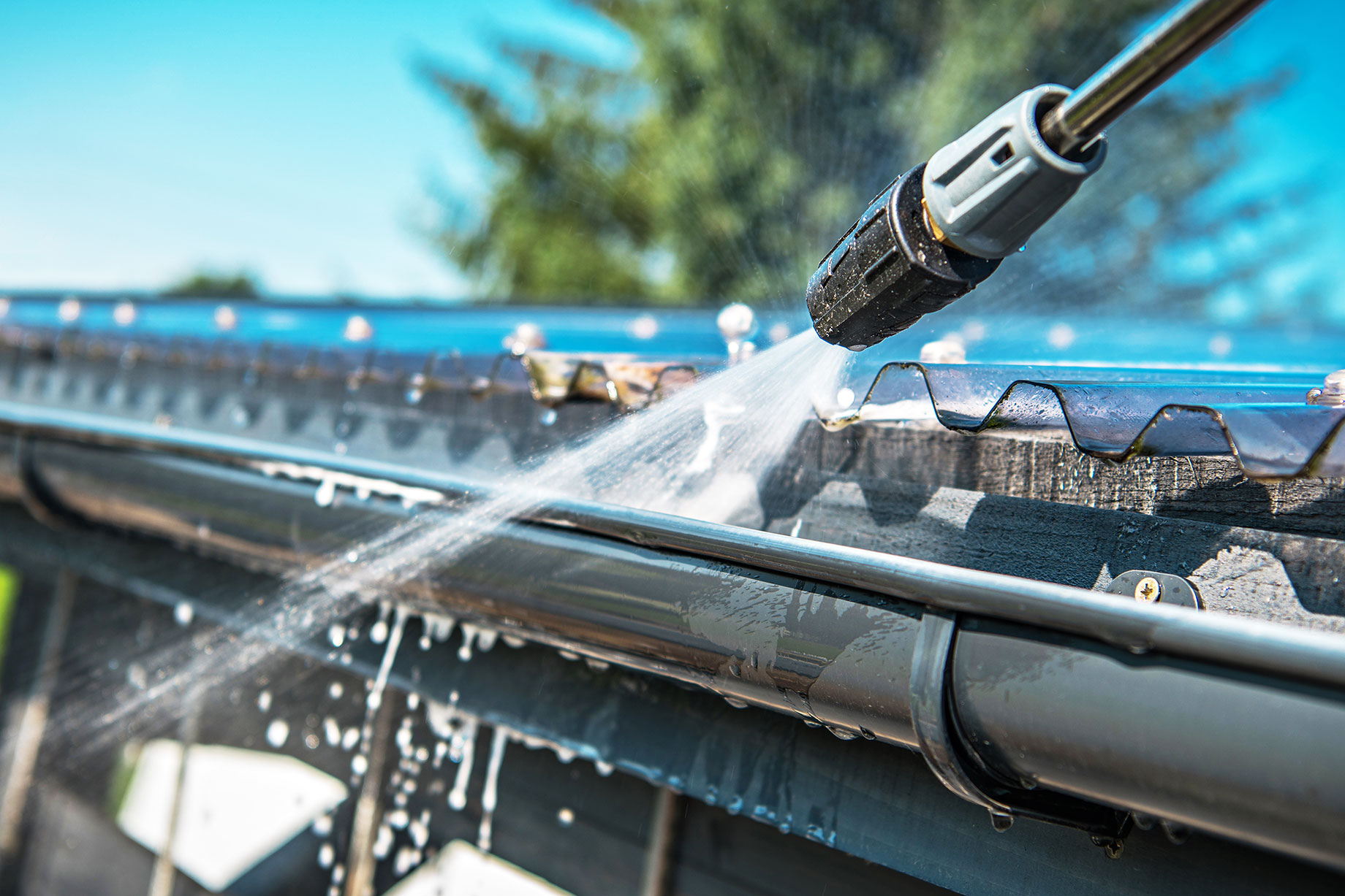 Spring Rain Gutters Cleaning Using Pressure Washer