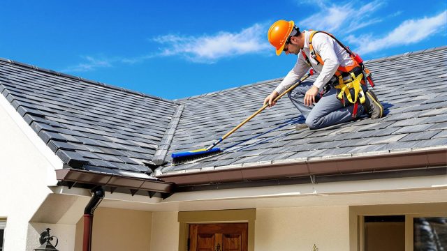 Roofer Cleaning a Well-Maintained Roof