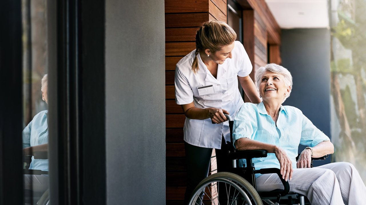 Senior Woman in a Wheelchair with a Caretaker
