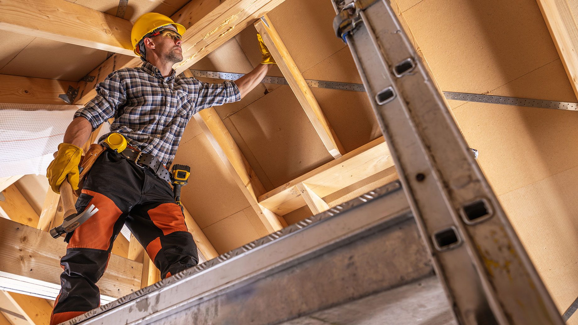 Construction Contractor Worker on a Scaffolding Performing Roof Elements Assembly