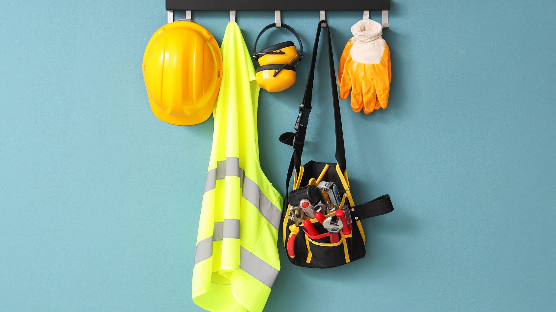 Safety Vest, Hardhat and Tools Hanging on Blue Wall