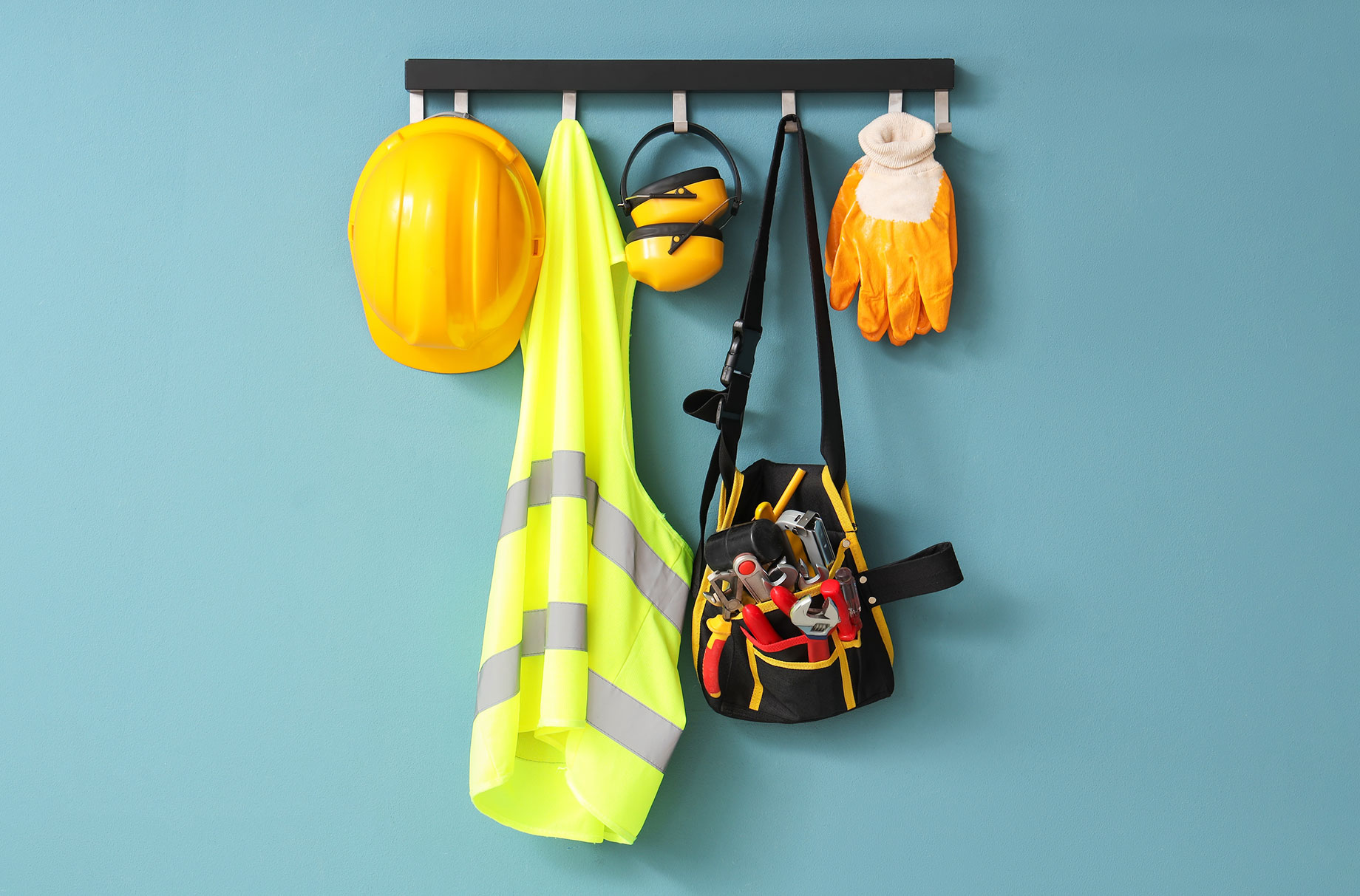 Safety Vest, Hardhat and Tools Hanging on Blue Wall