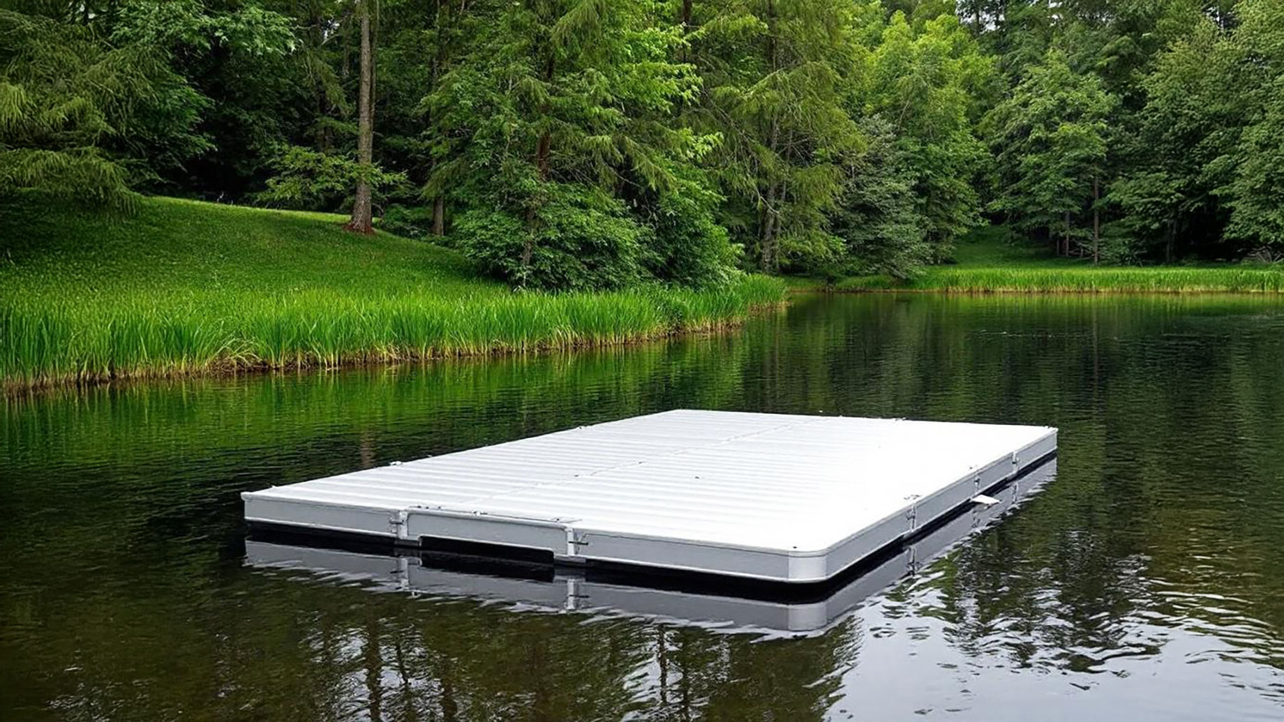 An aluminum floating dock on a calm lake, showcasing its modular and lightweight design in a lush, green environment.