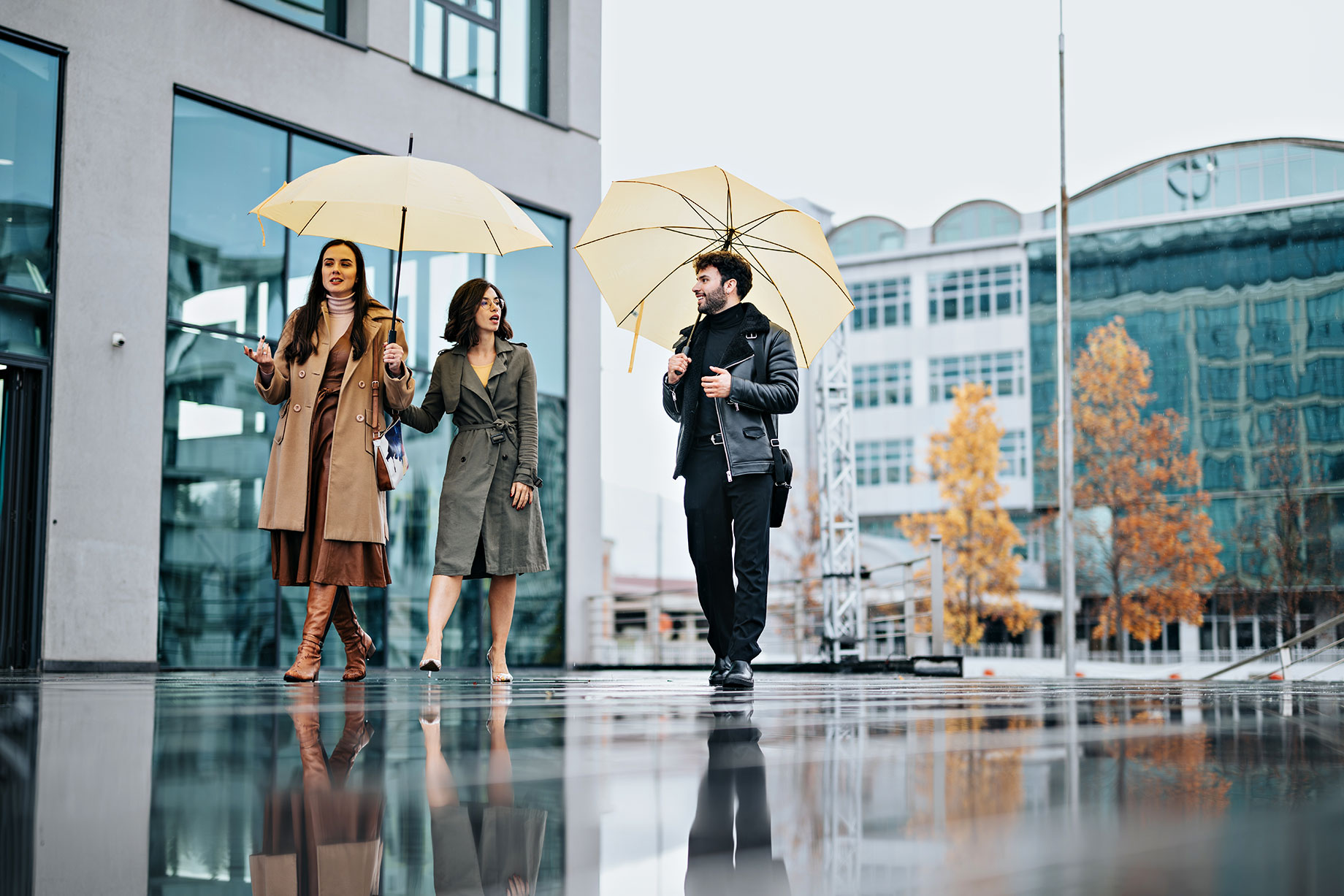 Three Business Professionals with Umbrellas, Walking in the Rain