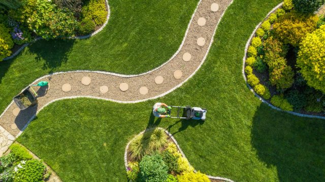 Aerial View of Landscape Maintenance with a Man Mowing the Lawn