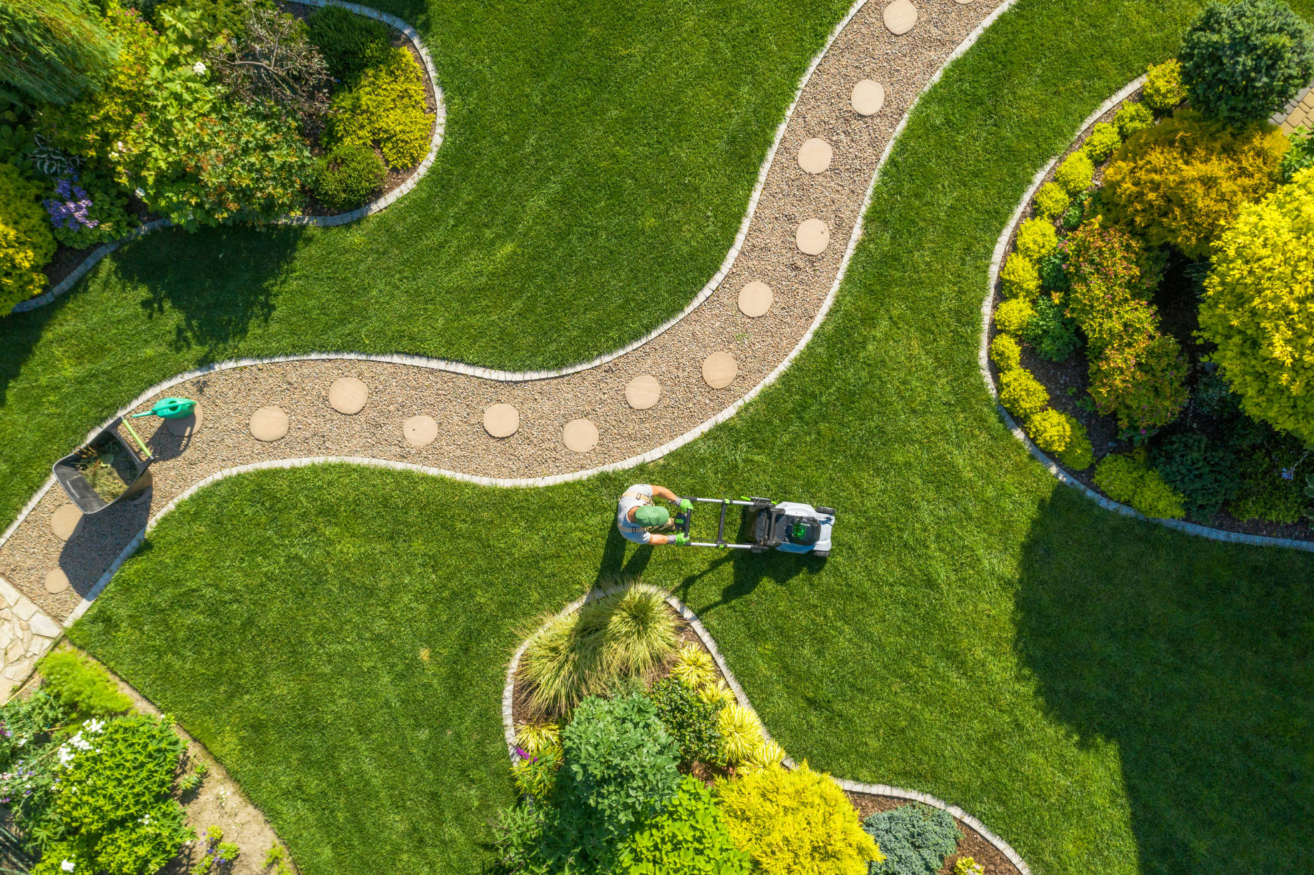 Aerial View of Landscape Maintenance with a Man Mowing the Lawn