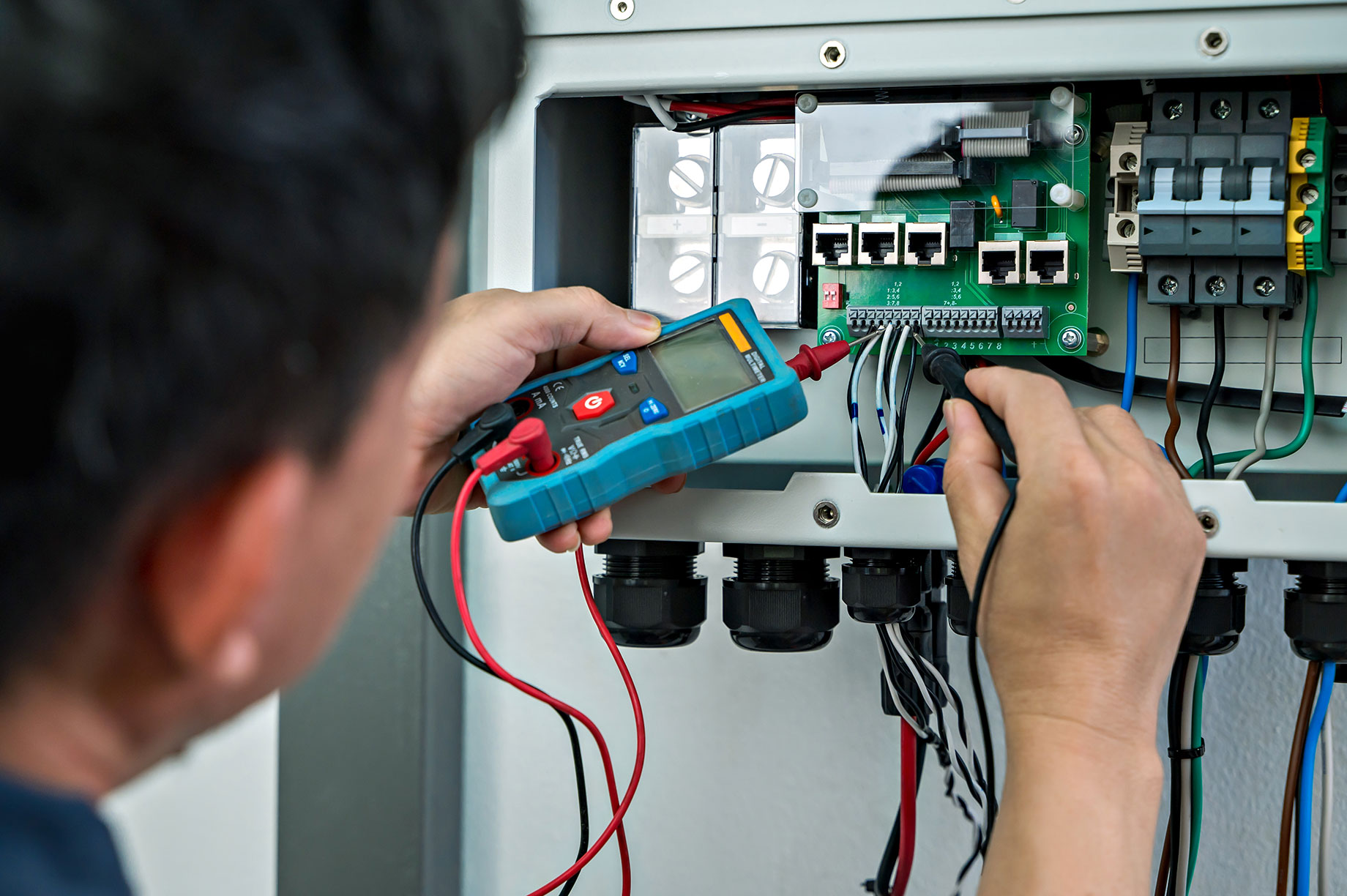 Electrician Checking Voltage From Home Use Solar Cell Combiner Box