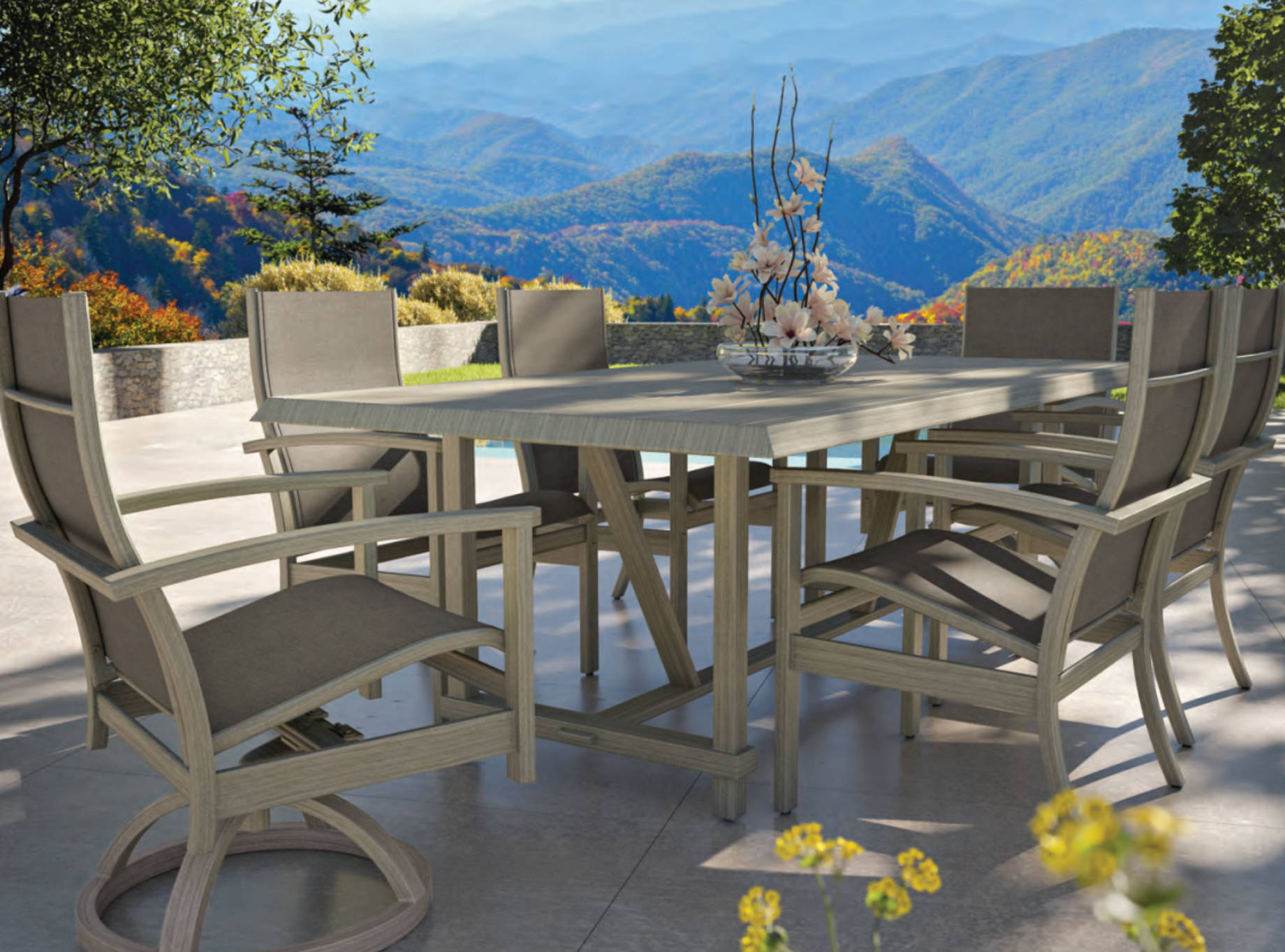 Luxury outdoor rectangular dining table with cushioned armchairs by Castelle, styled on a modern patio with mountain views and a floral centerpiece.)