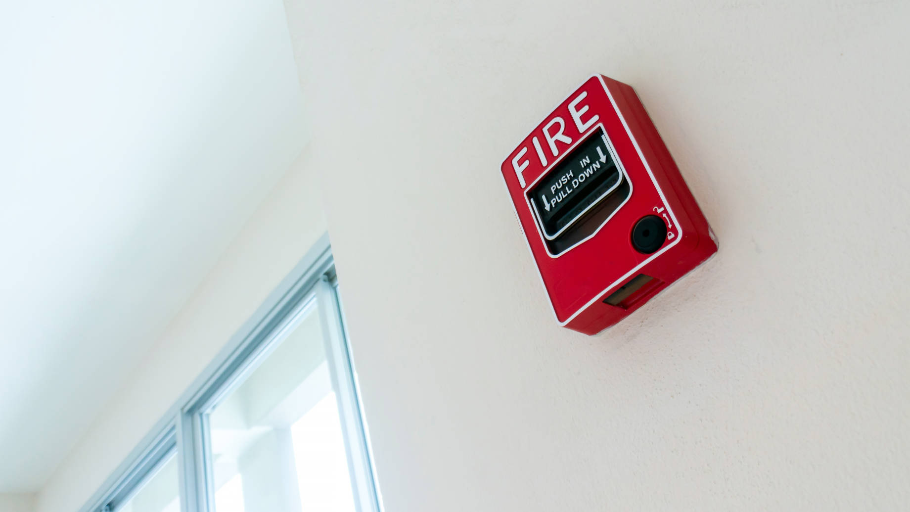 Red Fire Alarm Box Mounted on a Wall