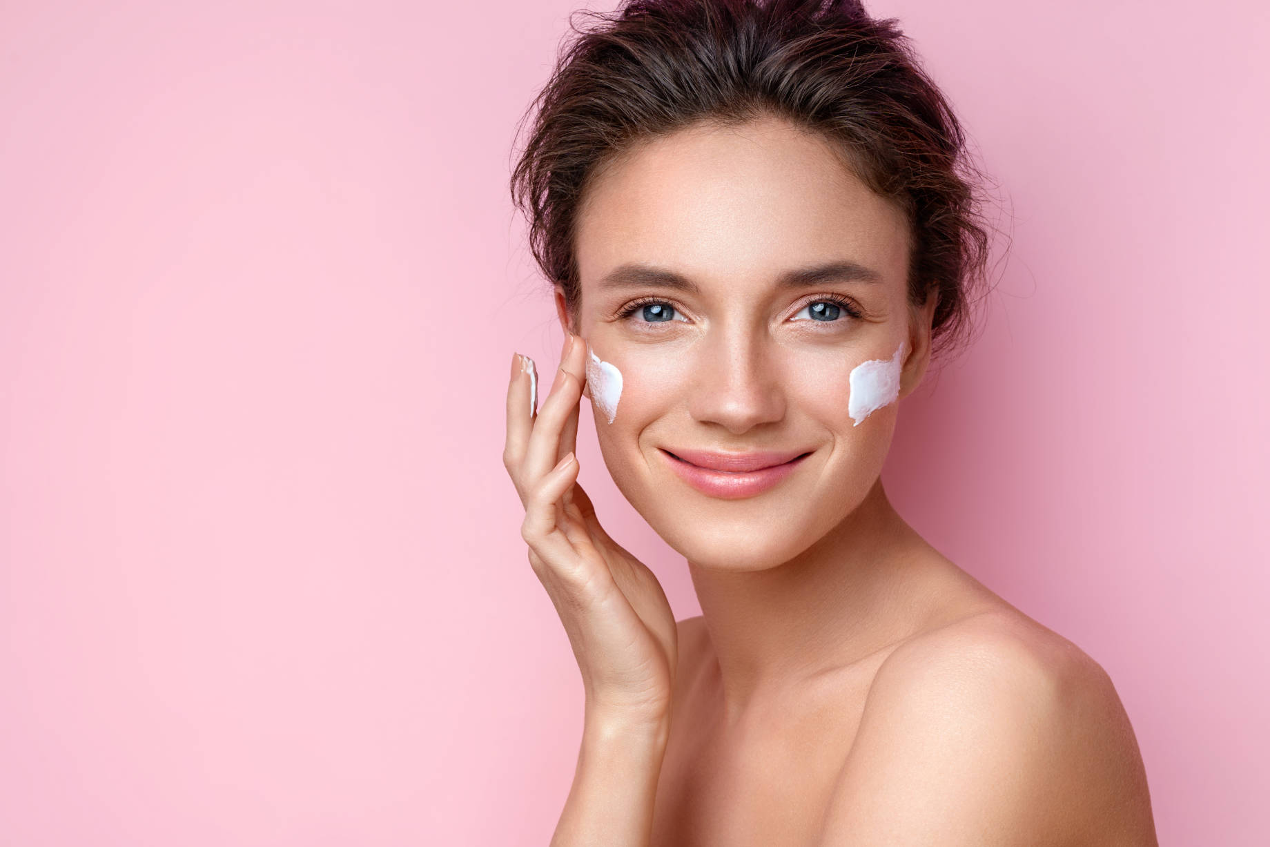 Woman Applying Moisturizer Cream on Her Face