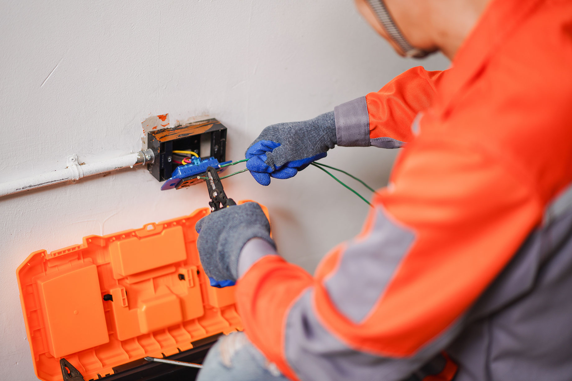 Electrician Carefully Connecting Wires in a Home