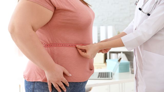 Female Doctor Measuring Waist of Overweight Woman
