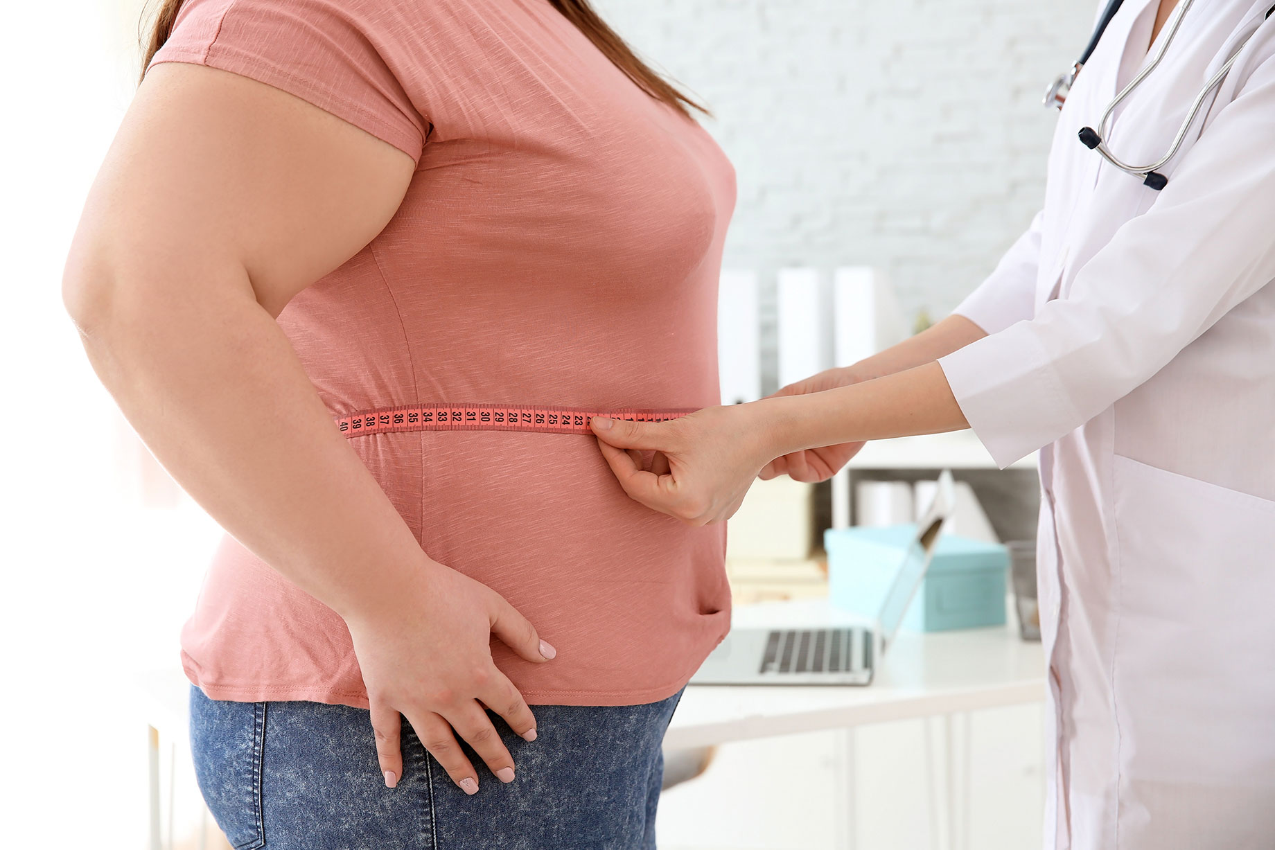 Female Doctor Measuring Waist of Overweight Woman
