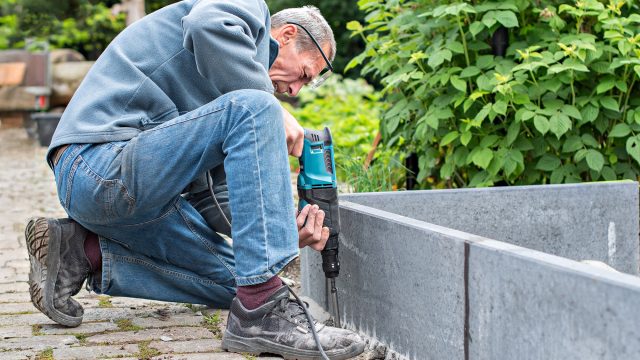 Middle-Aged Man Preparing Concrete Border Walls for a DIY Garden