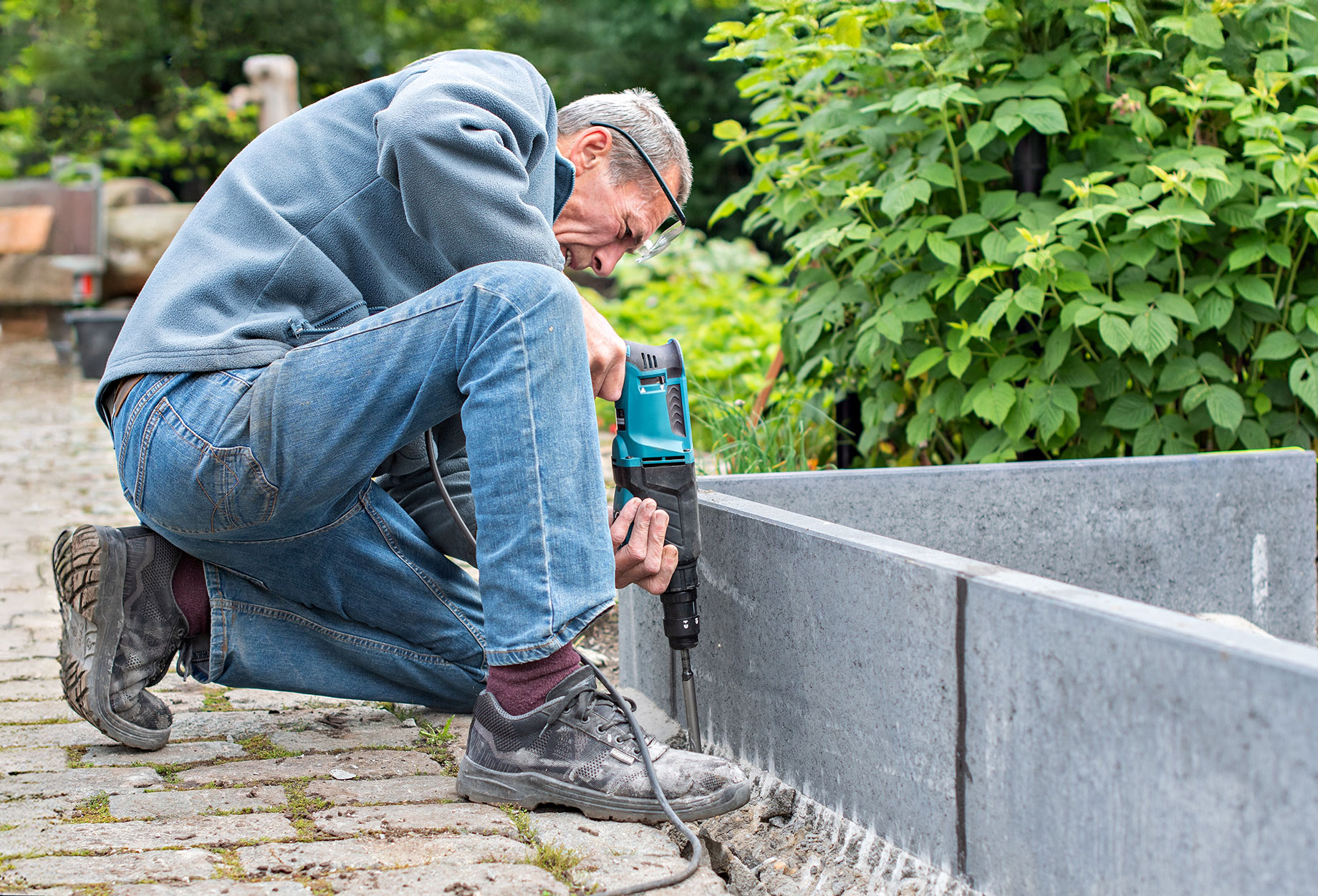 Middle-Aged Man Preparing Concrete Border Walls for a DIY Garden
