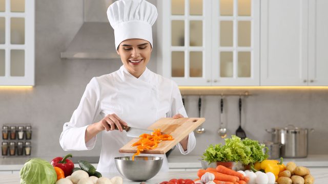 Professional Chef Cutting Vegetables in Modern White Kitchen