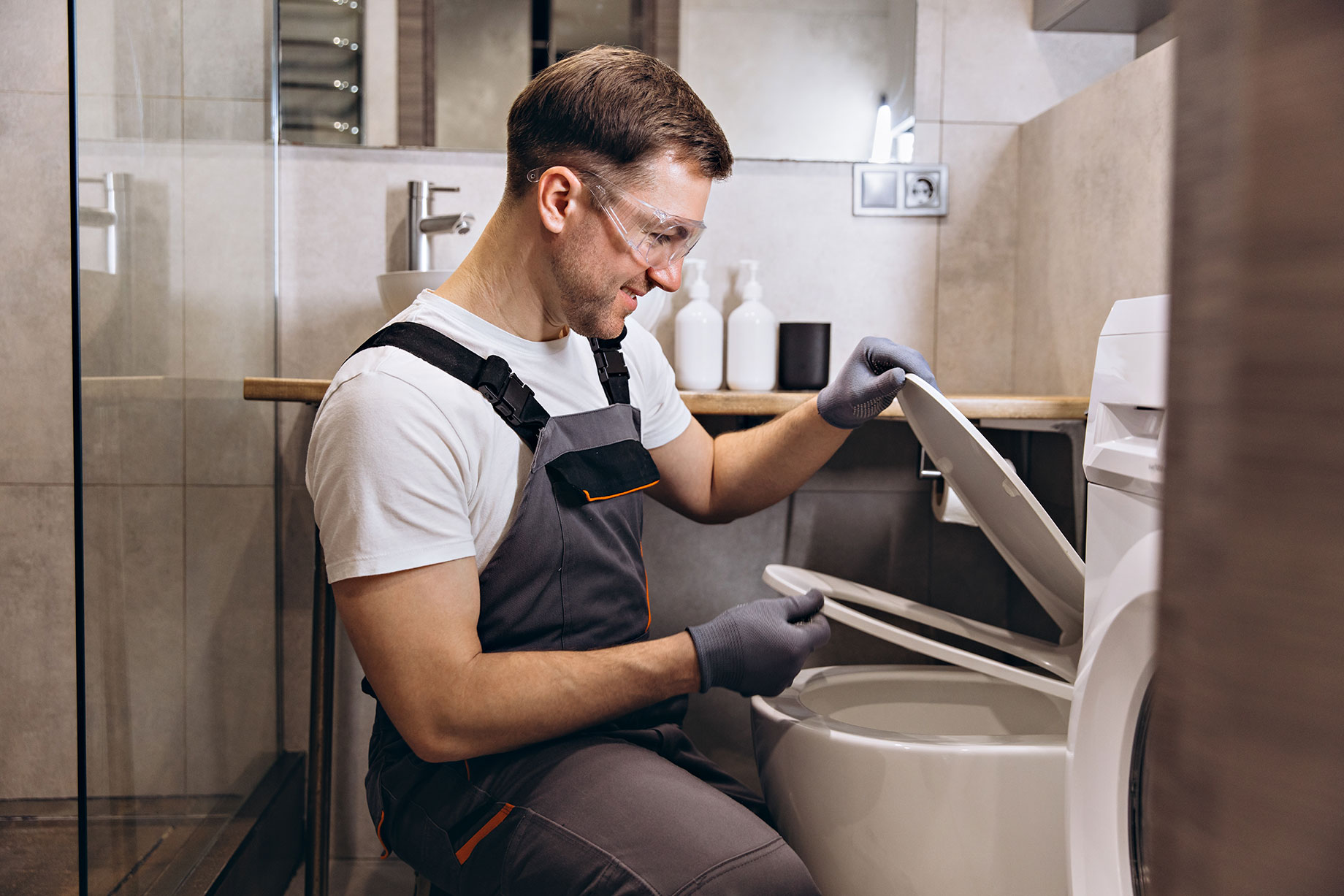 Professional Plumber Fixing a Toilet