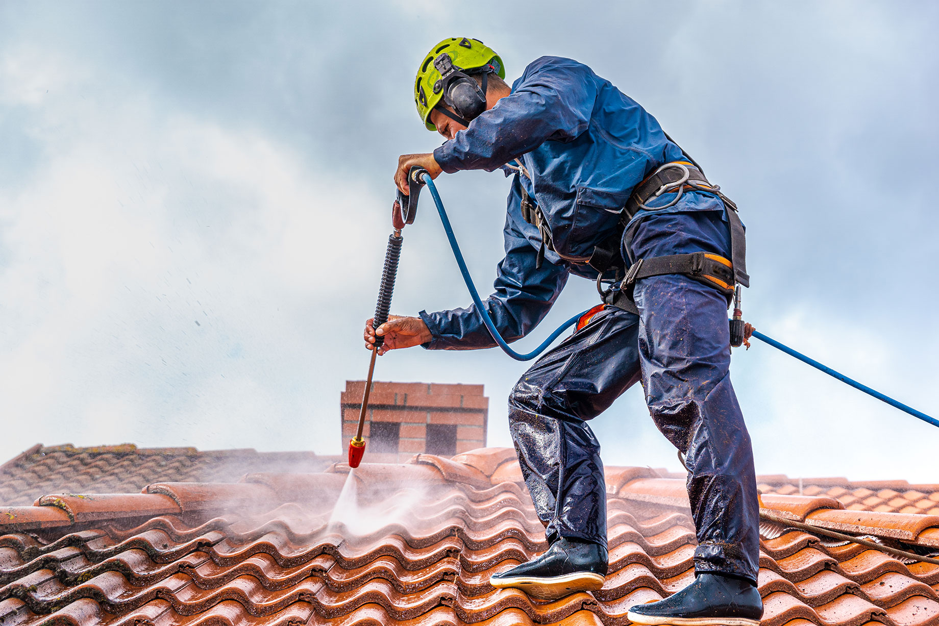 Professional Power Washing on the Roof of a House