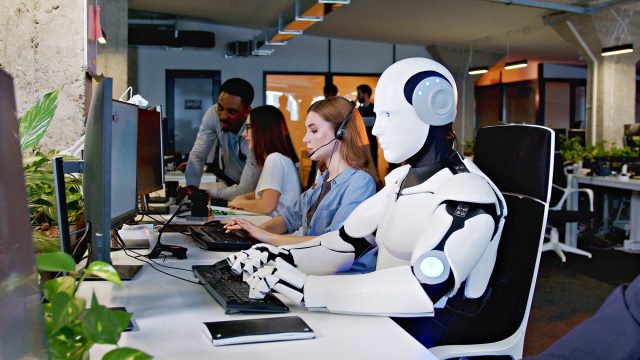 Robot with AI Working at Computer Among People