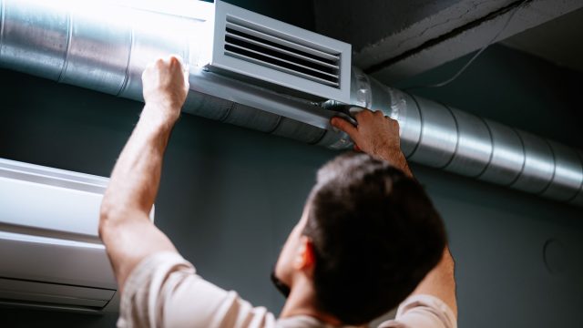 Technician Repairing Air Duct System