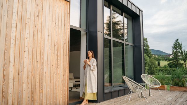 Woman on a Terrace of Modern House with Wooden Design Elements