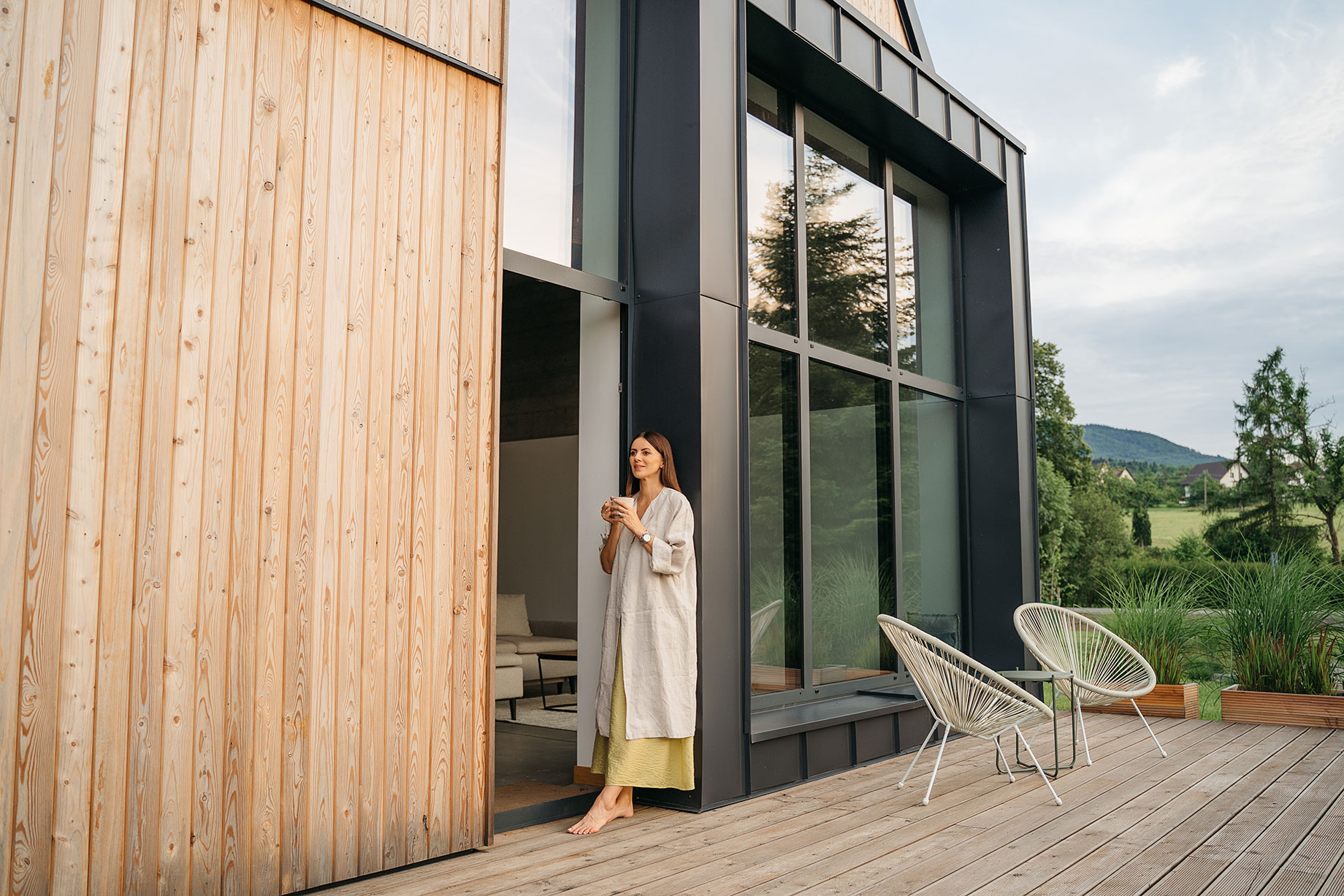 Woman on a Terrace of Modern House with Wooden Design Elements