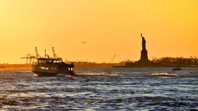 Cruising by the Statue of Liberty at Sunset Golden Hour in New York, USA