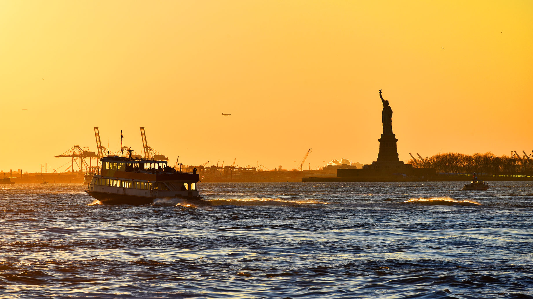Cruising by the Statue of Liberty at Sunset Golden Hour in New York, USA