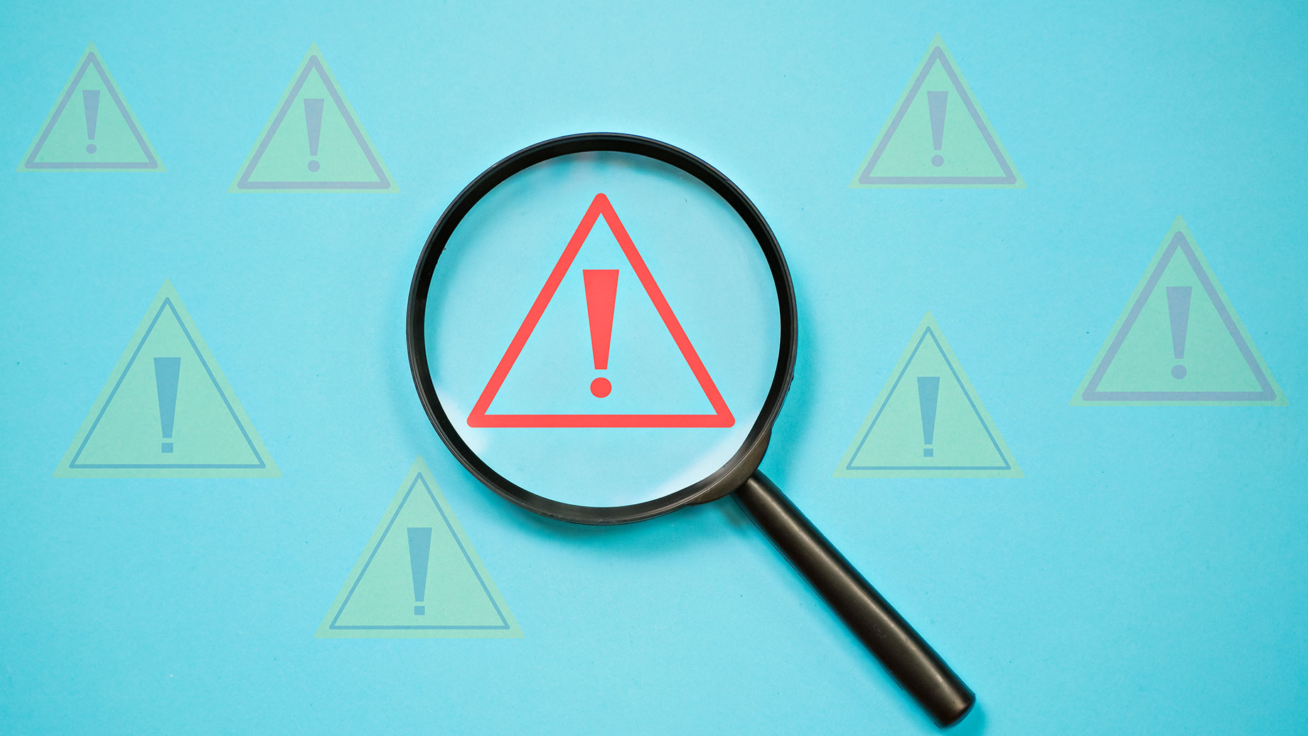 Magnifying Glass Highlighting a Red Warning Hazard Symbol