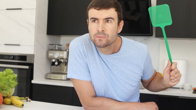 Man with a Fly Swatter in His Kitchen