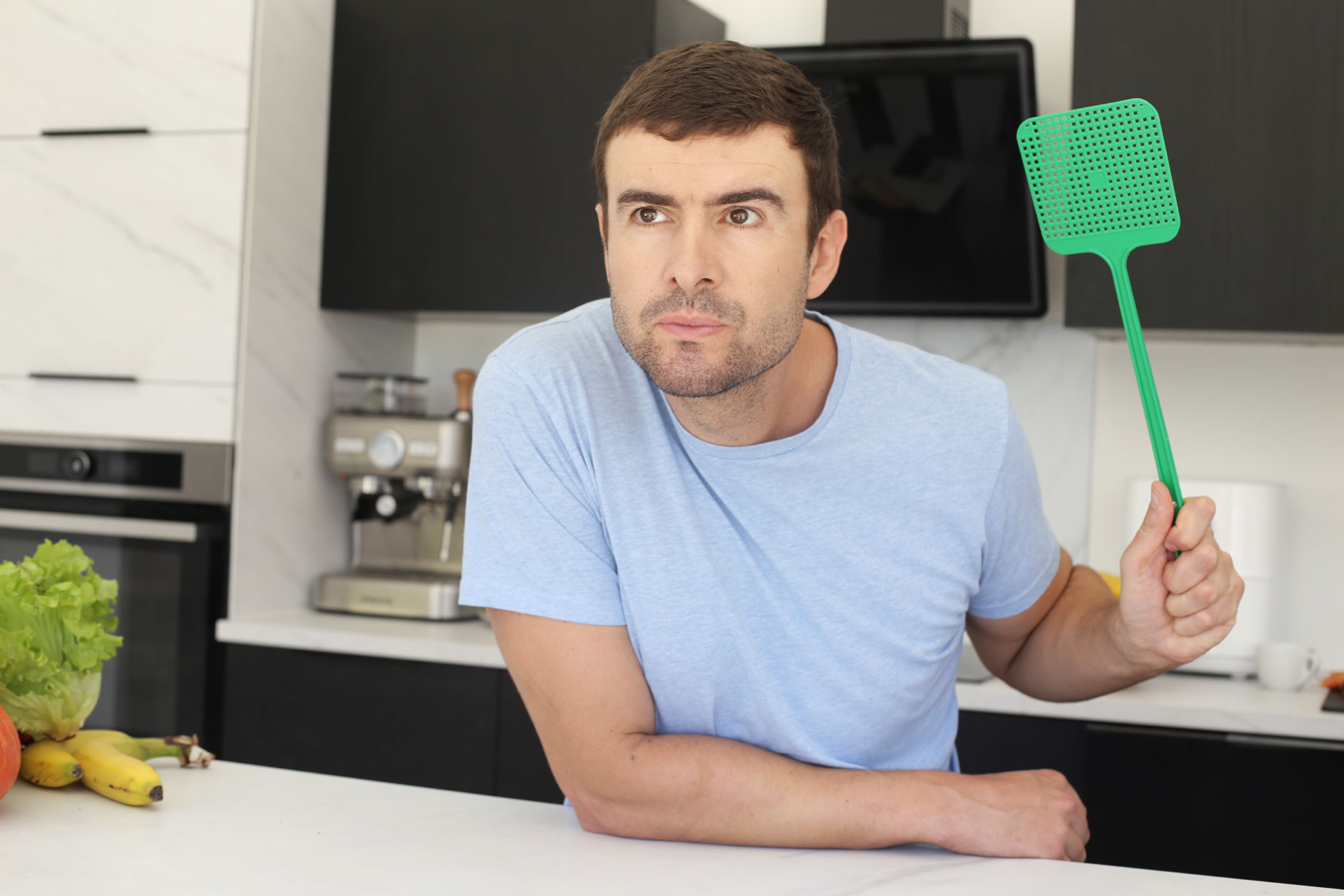 Man with a Fly Swatter in His Kitchen