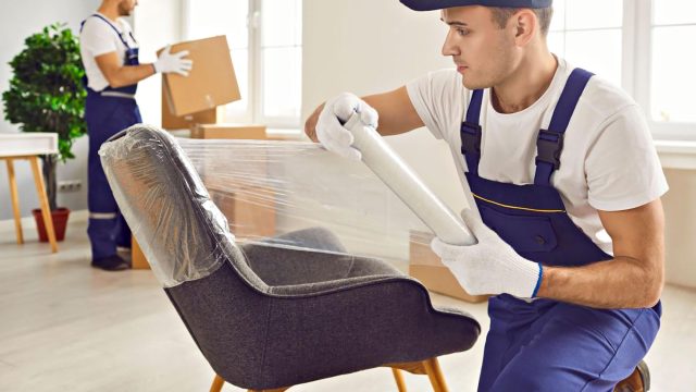 Professional Mover Wrapping a Chair for Packing