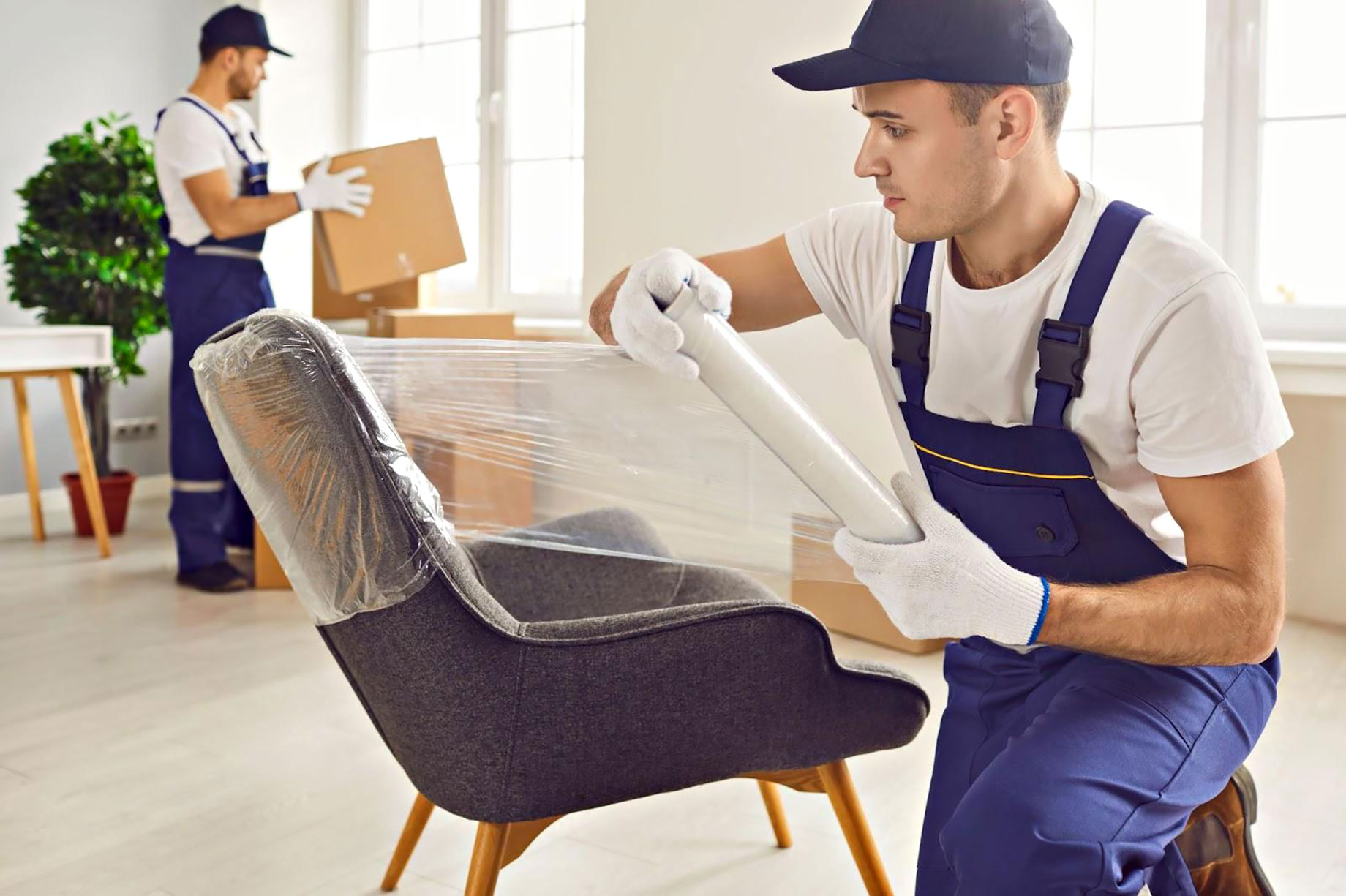 Professional Mover Wrapping a Chair for Packing