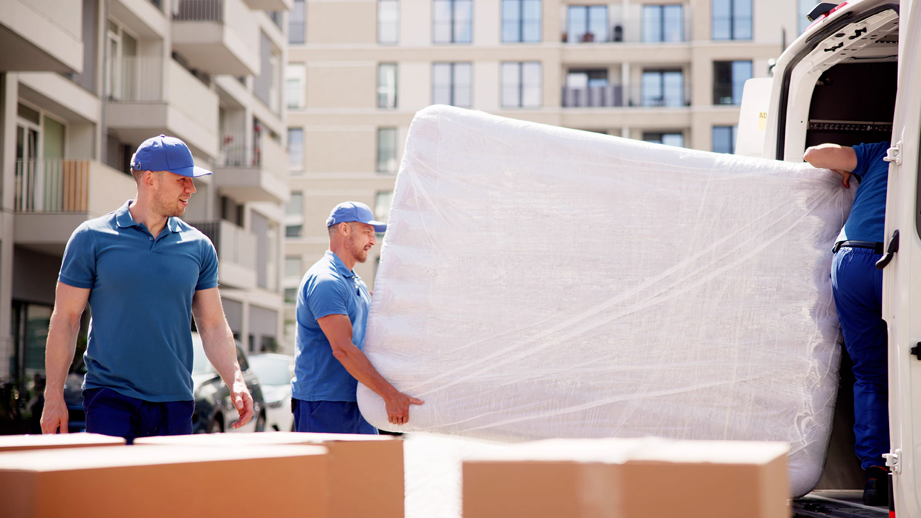 Professional Movers Packing a Mattress in a Truck