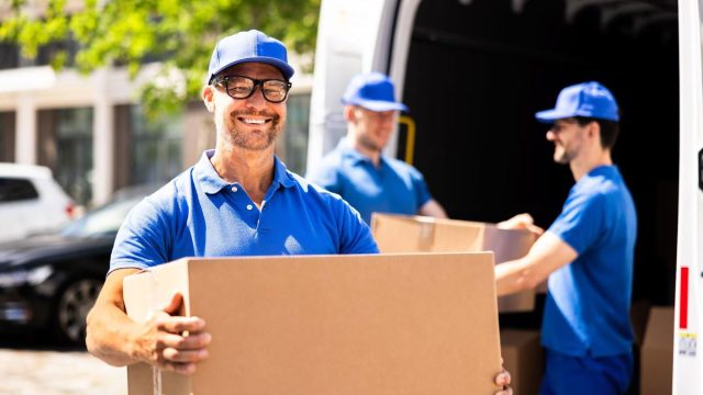Professional Movers Unloading Boxes from Truck