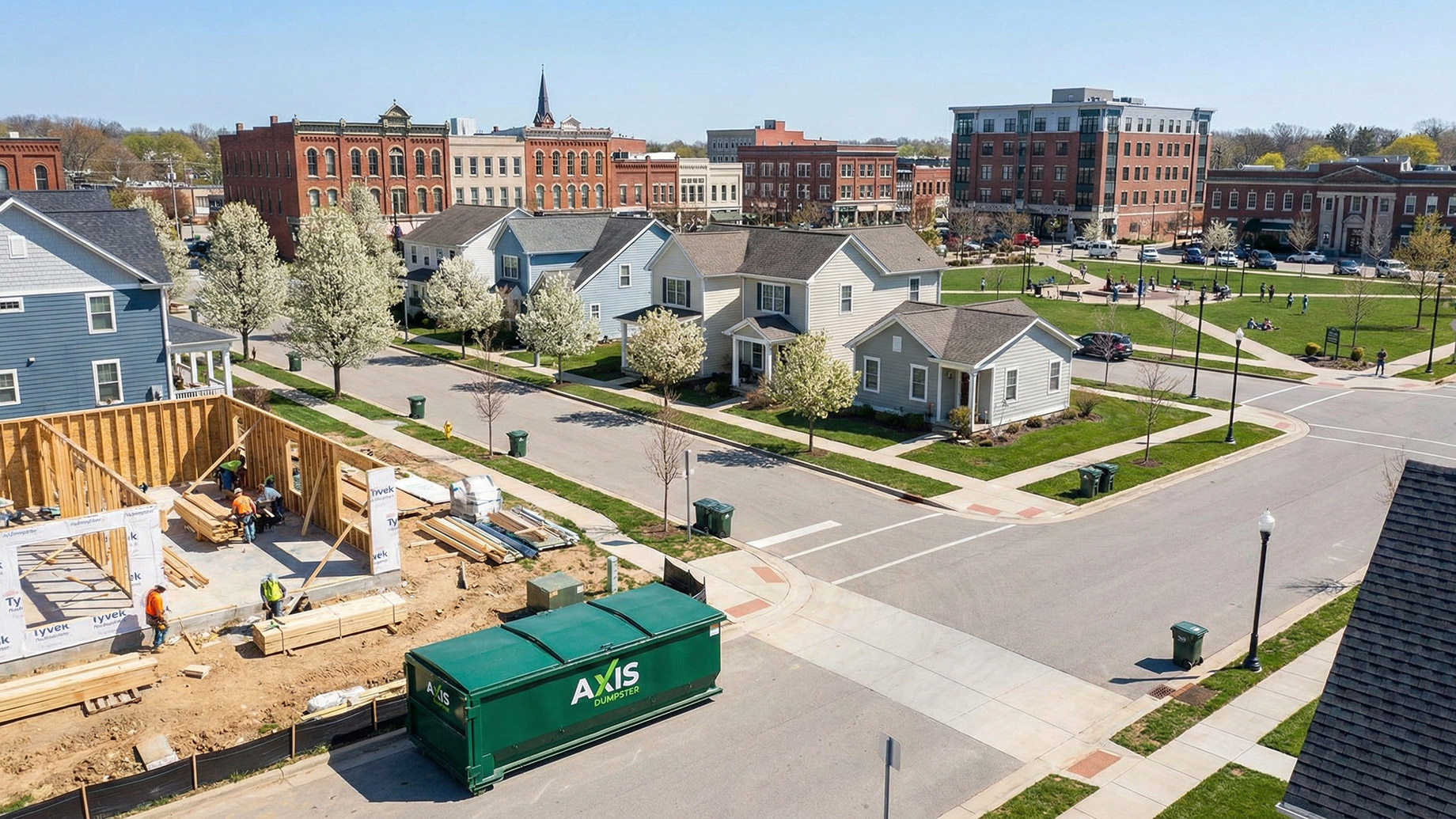 A clean, organized residential neighborhood featuring a tidy construction site with a green Axis Dumpster, illustrating effective waste planning, clear streets, and safe community growth.