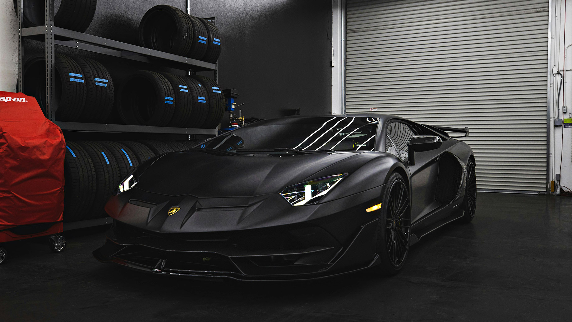 Matte Black Lamborghini Aventador in a Garage