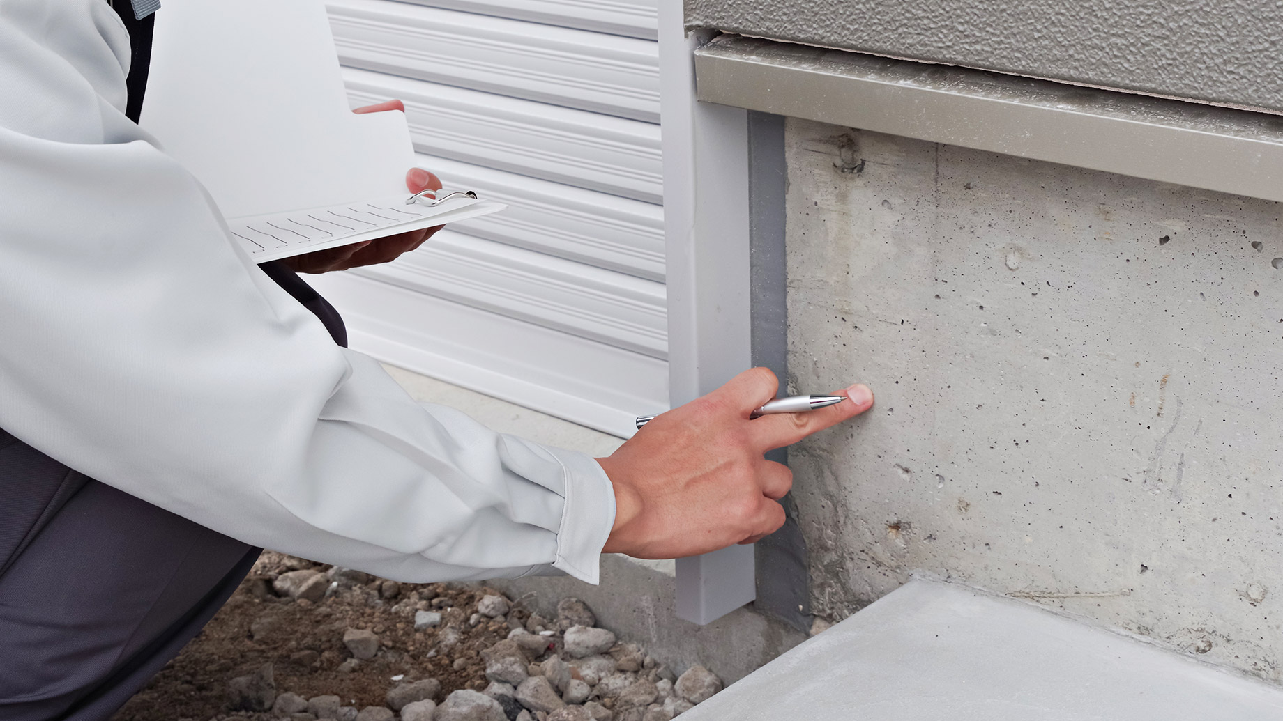 Professional Inspecting the Foundation of a House