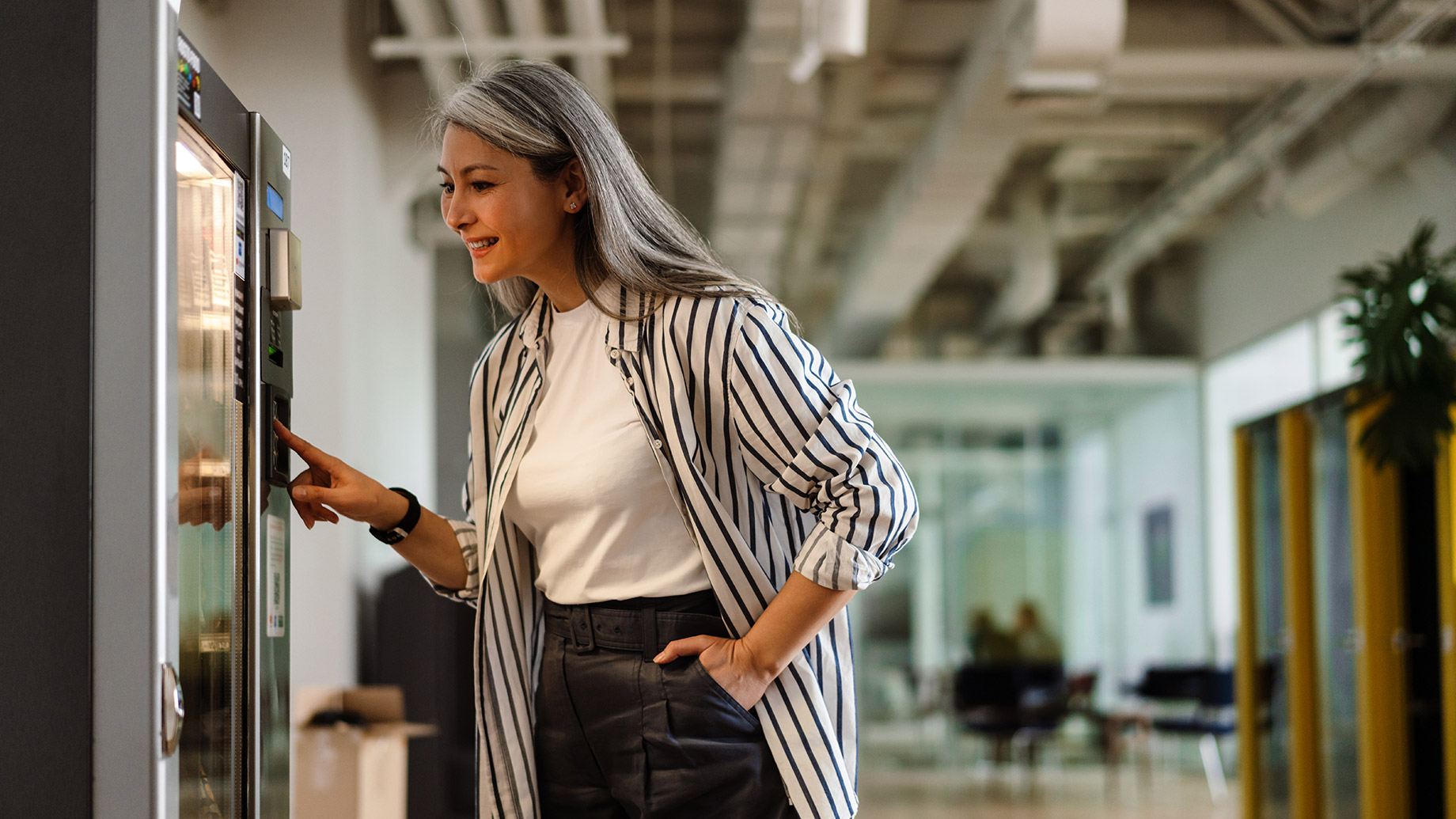 Woman Using a Vending Machine at a Corporate Office