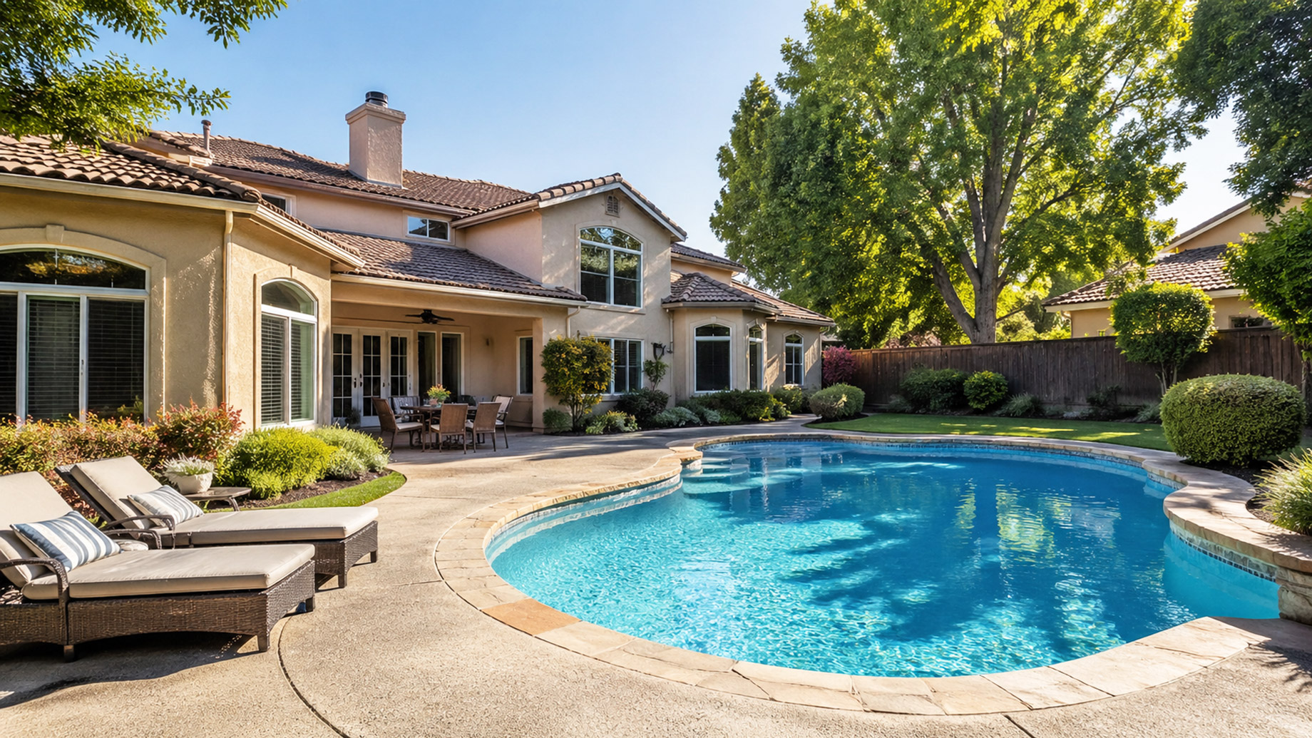 Two-story Sacramento home with a backyard swimming pool, lounge chairs, and landscaped patio on a sunny day.