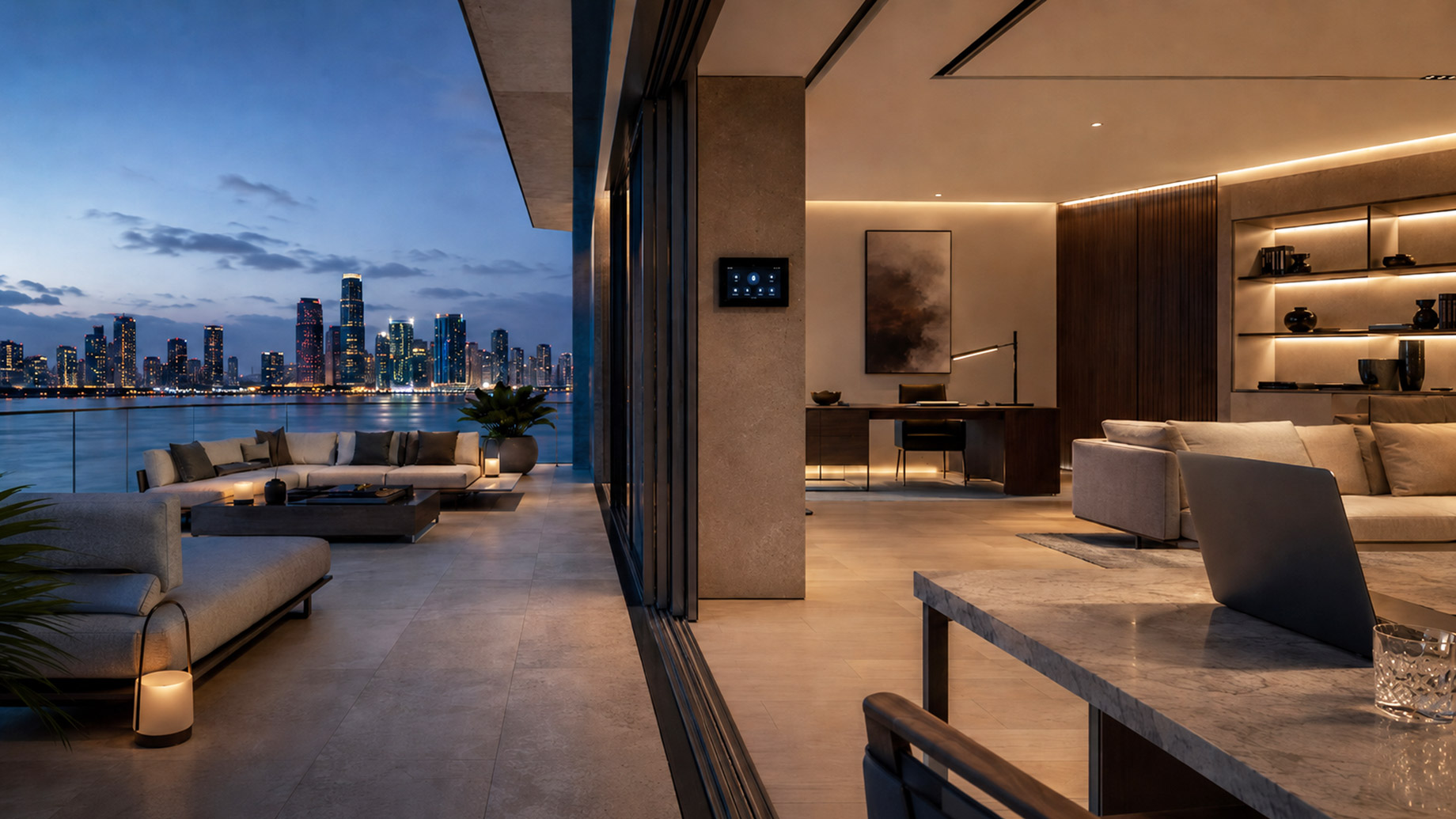 A modern luxury penthouse opens to a waterfront terrace at dusk, with a smart-home control panel, laptop workspace, and city skyline views across the water.