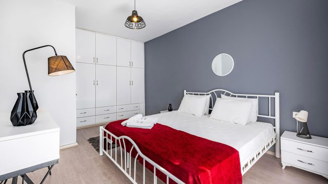 Contemporary Bedroom with a White Bed and Vibrant Red Blanket with Minimal Decor