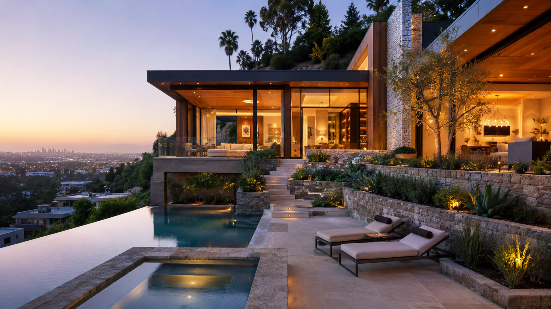 Luxury Los Angeles hillside estate with glass walls, stone terraces, warm interior lighting, an infinity pool, and city views at dusk.