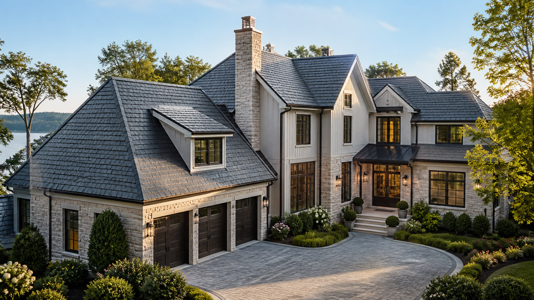 Luxury home with a premium slate roof, stone facade, manicured landscaping, and elegant architectural details.
