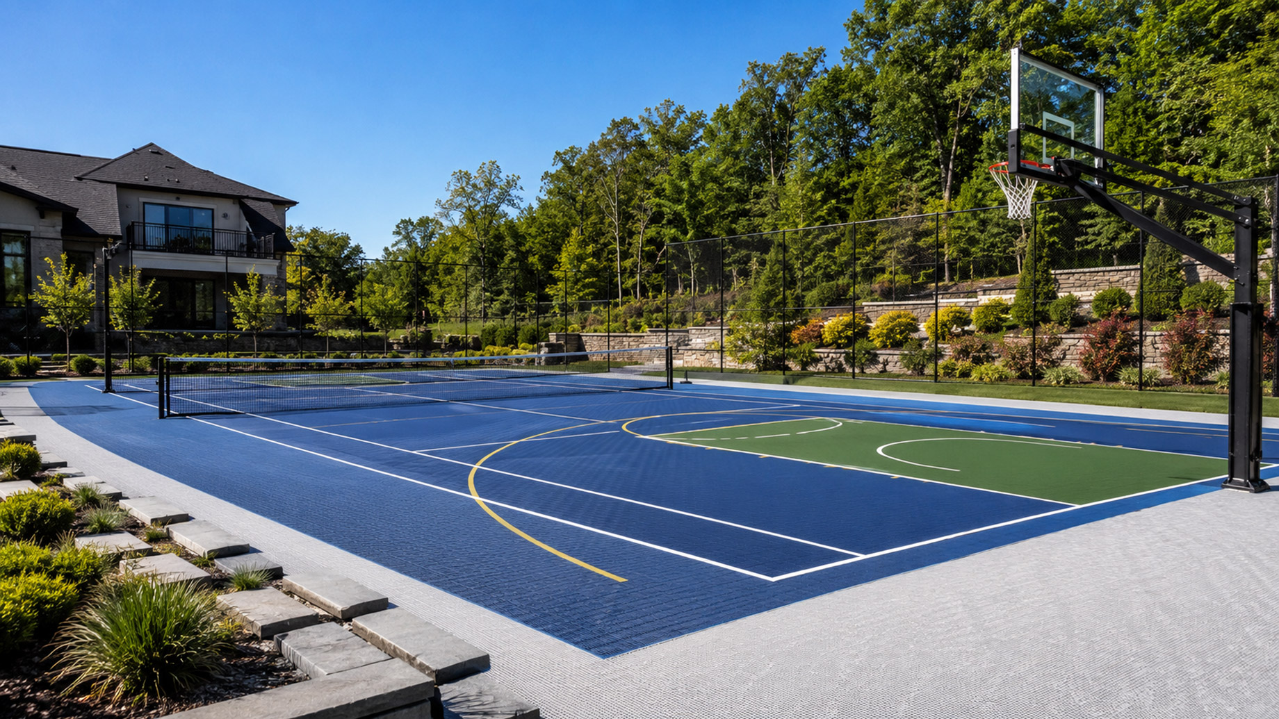 Luxury outdoor multi-sport court with basketball hoop, tennis net, professional surfacing, and landscaped residential surroundings.