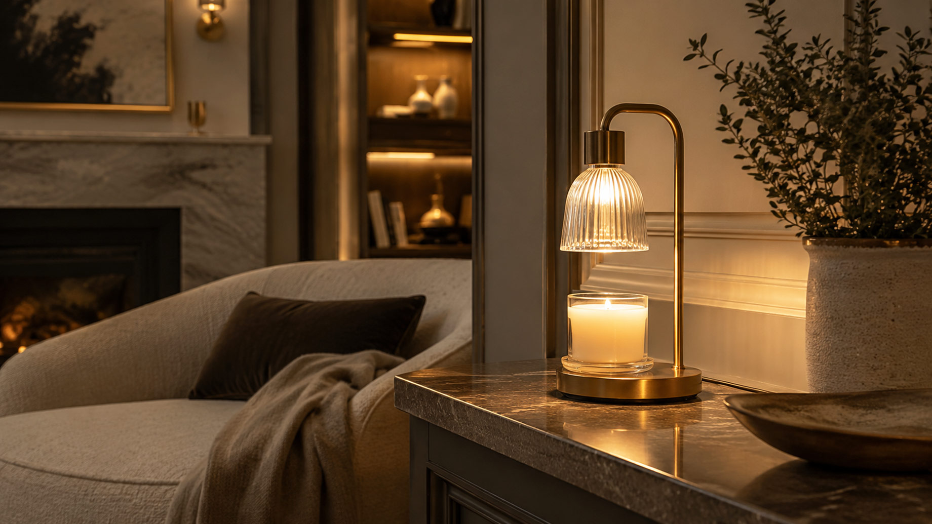 Brass candle warmer lamp illuminating a scented jar candle on a marble side table in an elegant, warmly lit living room.